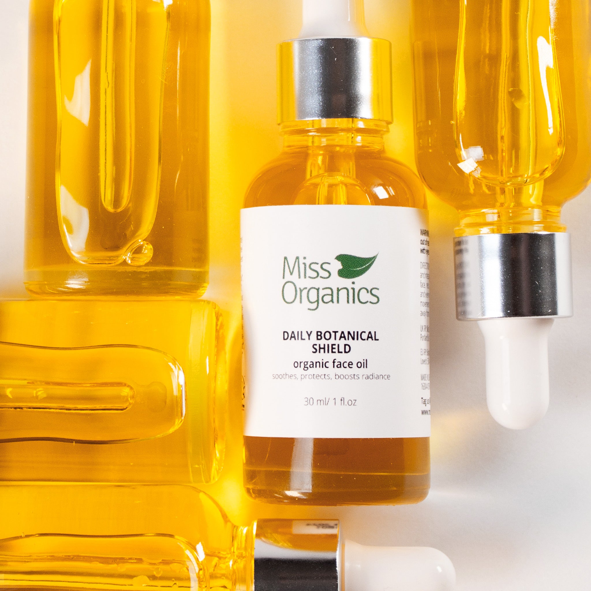 Daily Botanical Shield Organic Face Oil in glass bottle on cream background by Miss Organics