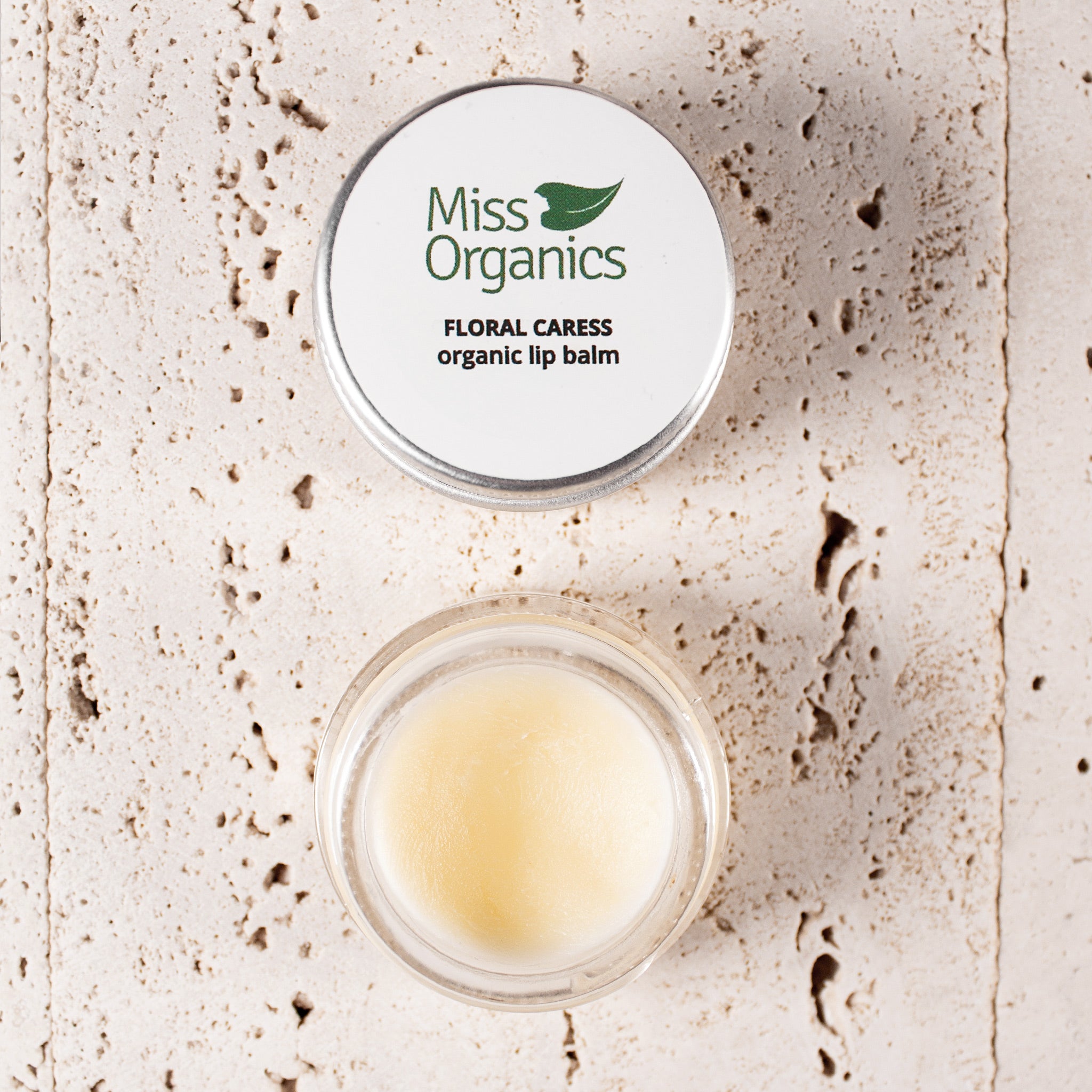 Floral Caress organic lip balm in glass pot on stone background
