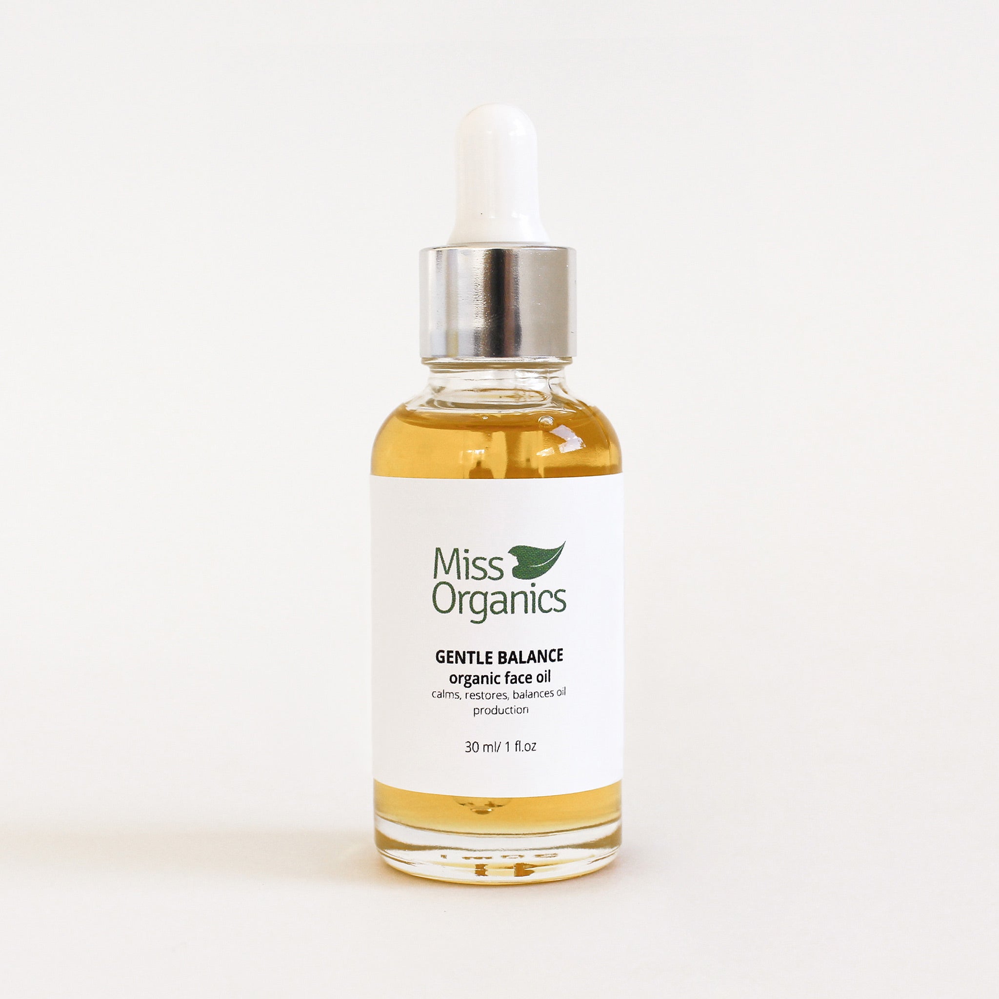 Gentle Balance Organic Face Oil in glass bottle on cream background