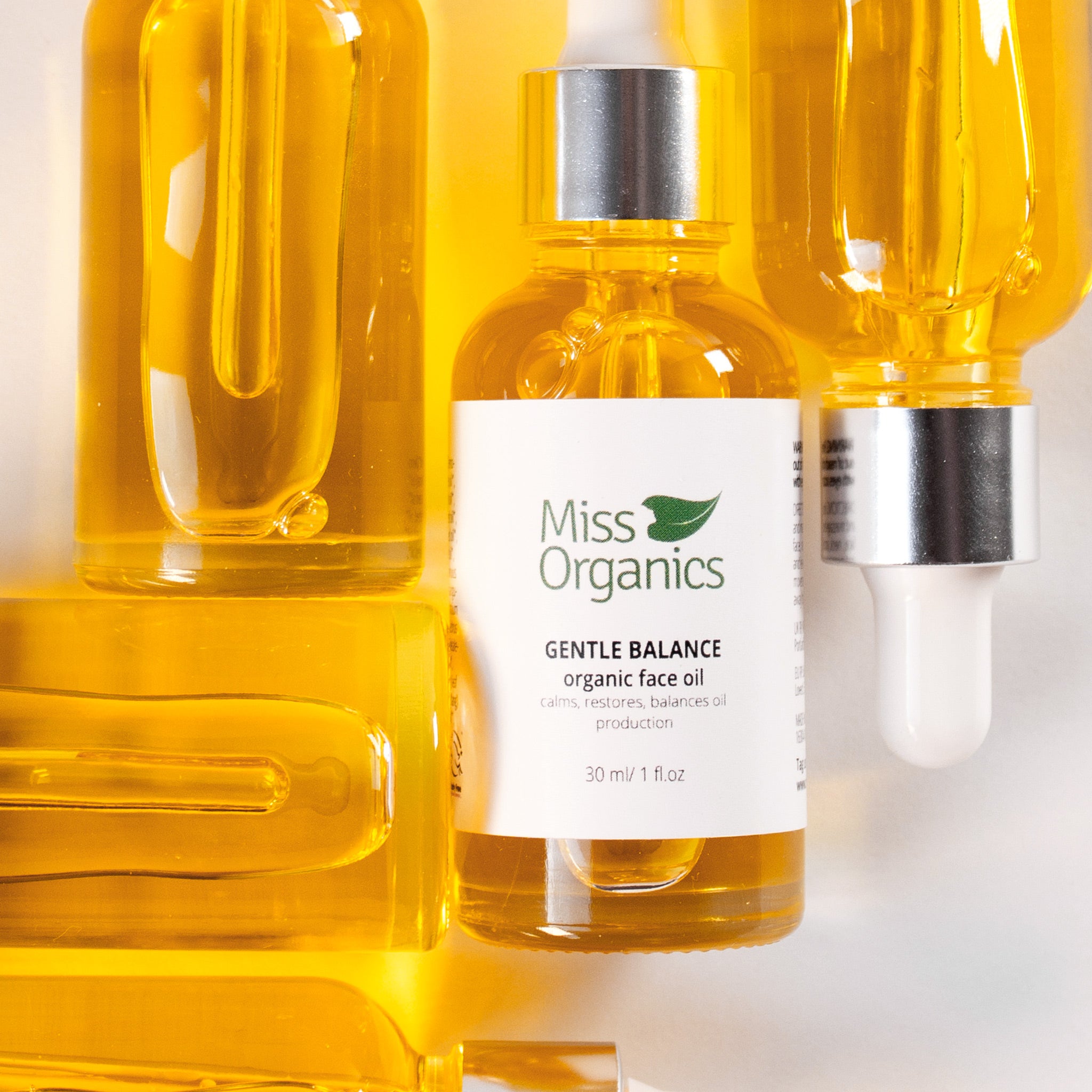 Gentle Balance Organic Face Oil in glass bottle on stone background by Miss Organics