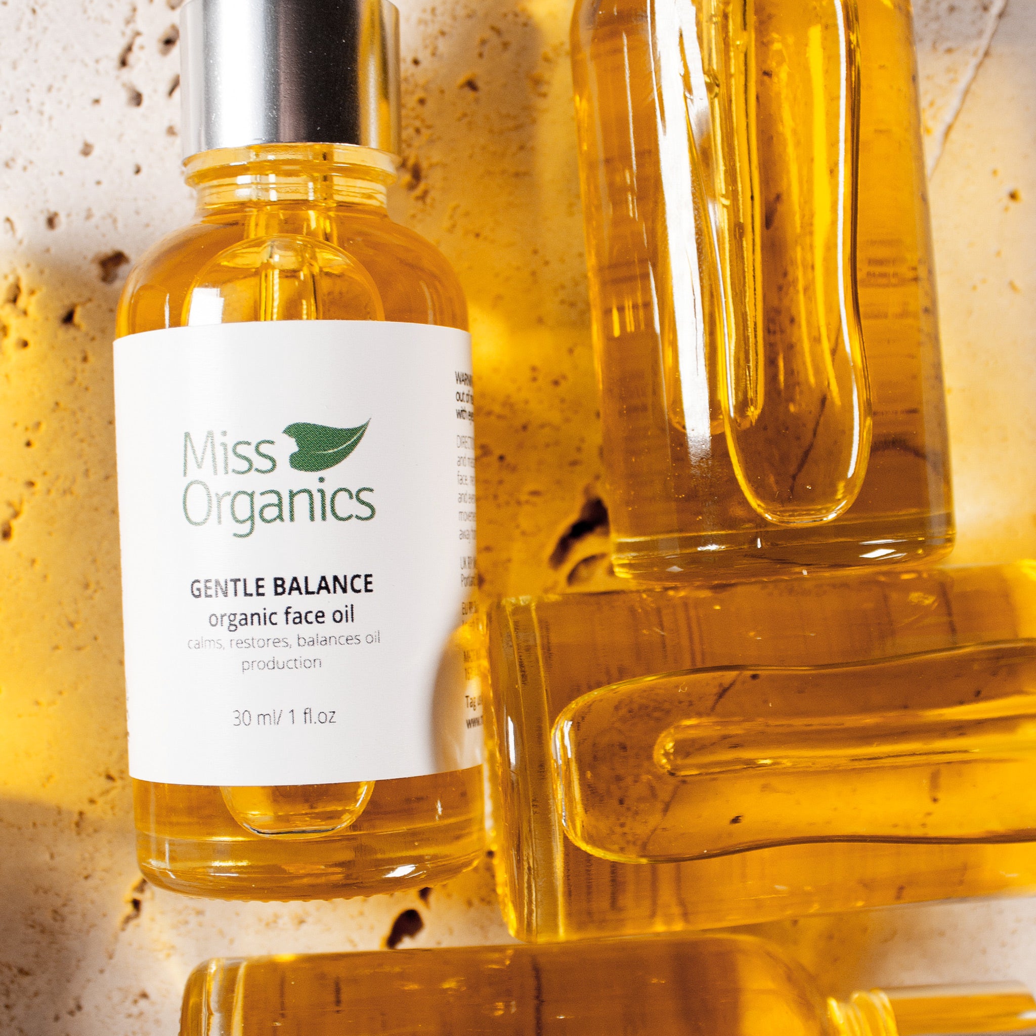Gentle Balance Organic Face Oil in glass bottle on stone background
